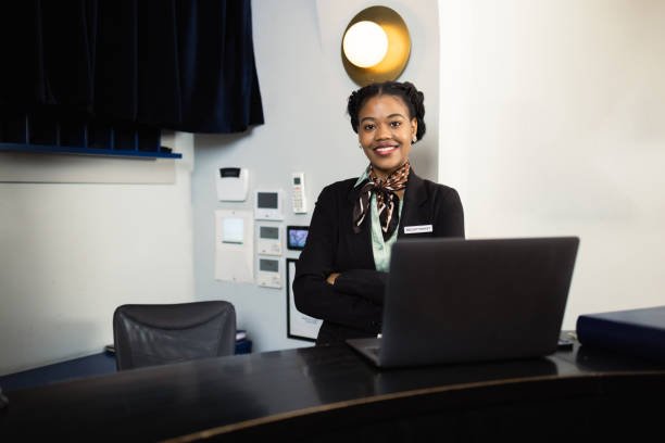 African American female hotel receptionist working at the reception desk of the hotel